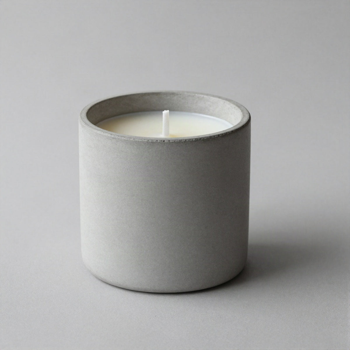 Matte concrete candle styled on a shelf